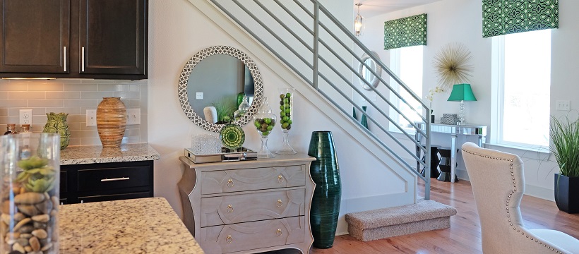 At the edge of the kitchen and living room, a modern stairway appears in one of South Austin’s discounted inventory homes.