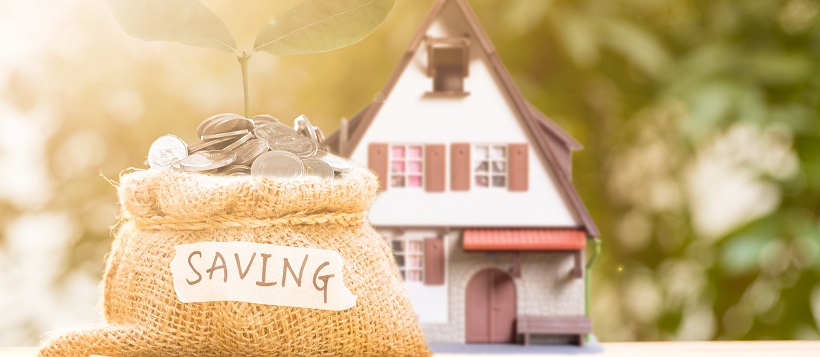 A miniature home with a bag of savings and a plant sprouting from within the pile of coins.