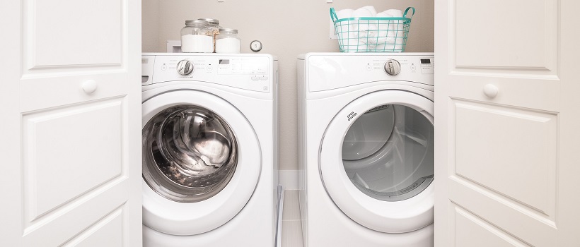 White laundry doors open to reveal a white washer and dryer.