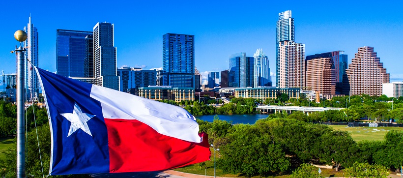 Texas flag flying with the downtown Austin skyline in the background to represent what is seen for Californians moving to Texas.