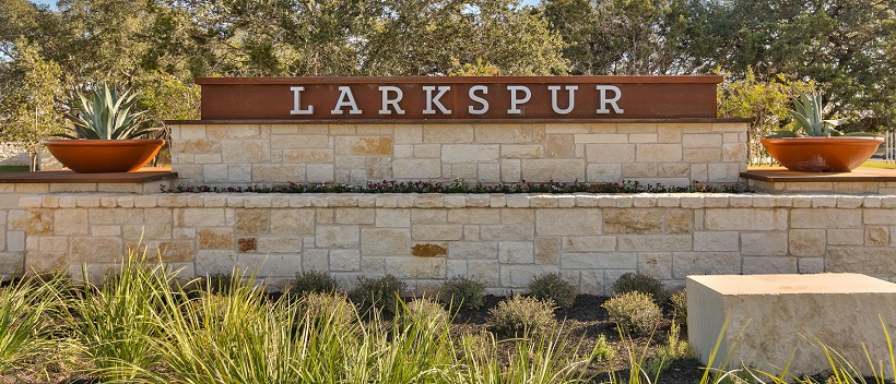 The Larkspur stone front entrance surrounded by Texas Hill Country landscaping. 