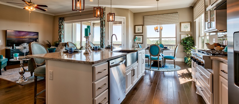 Open-concept floor plan displaying luxurious kitchen connected to the dining room and living room.