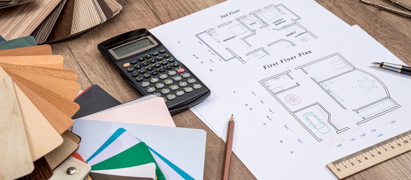 Color wheels sprawled out near a calculator sitting on top of two-floor plan drawings.